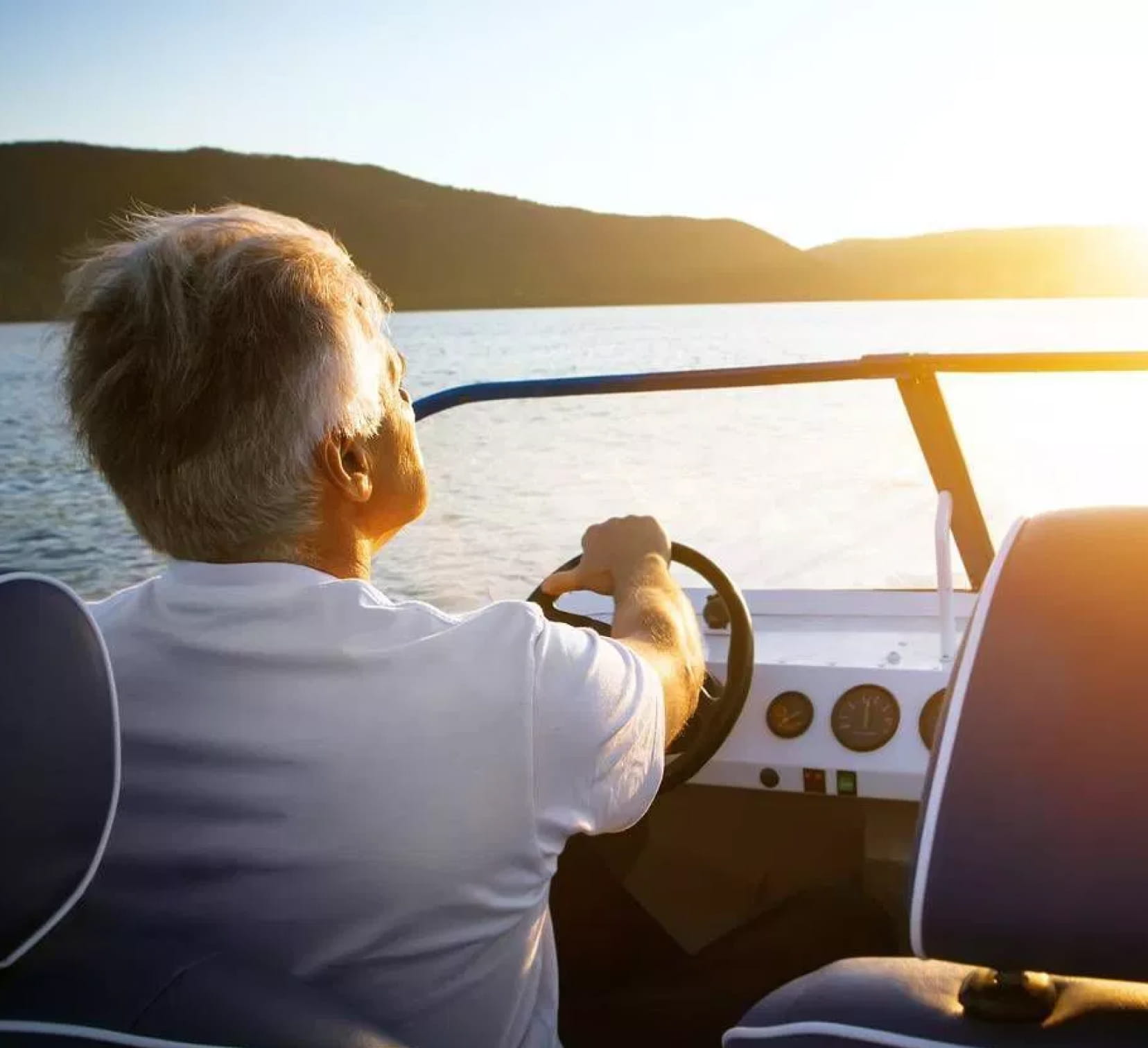 Une personne conduisant un bateau sous un coucher de soleil